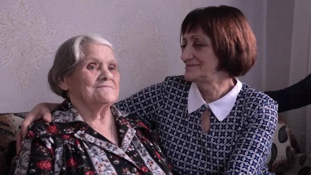 Kadın yaşlı bir ebeveyni ziyaret ediyor. Yetişkin kız çok yaşlı annesine sıkıca sarılıyor.. — Stok video