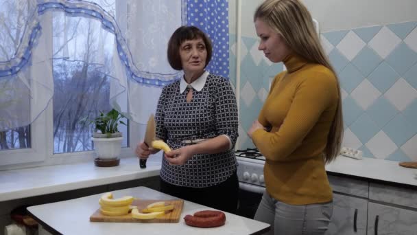 Zwei Generationen in der Küche. Mutter bringt ihrer Tochter das Kochen bei — Stockvideo