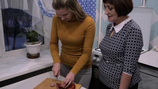 Zwei Generationen in der Küche. Mutter bringt ihrer Tochter das Kochen bei — Stockvideo