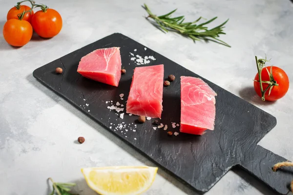 Çiğ ton balığı filetosu. Beton bir arka planda deniz ürünleri.
