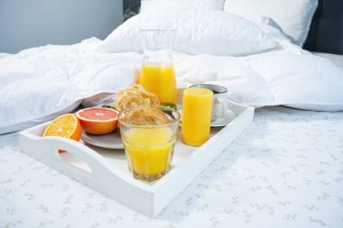 Yatakta kahvaltı. Kahve, kruvasan, taze portakal suyu ve meyve..