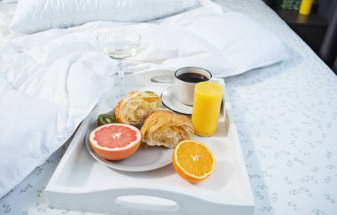 Yatakta kahvaltı. Kahve, kruvasan, taze portakal suyu ve bir bardak şampanya..