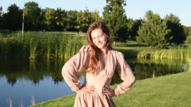 Bahar parkında dans eden gülümseyen kadın portresi. Kapalı genç bir bayan yaz günü kendini özgür hissediyor..