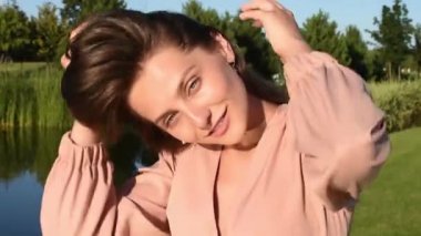 Bahar parkında dans eden gülümseyen kadın portresi. Kapalı genç bir bayan yaz günü kendini özgür hissediyor..