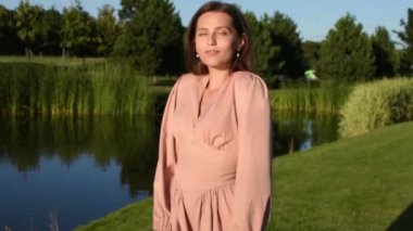 Bahar parkında dans eden gülümseyen kadın portresi. Kapalı genç bir bayan yaz günü kendini özgür hissediyor..