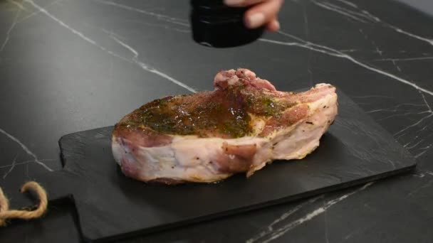 厨师在石板上的一块新鲜生肉上撒调味料 — 图库视频影像