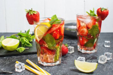 Yaz ferahlatıcı mojito kokteyli çilekli, naneli ve limonlu. Koyu taş masada içkileri çırpmak için.