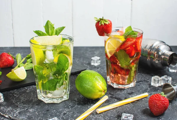 stock image Fresh Mojito cocktail set with lime, mint, strawberry and ice in glass on stone background. Summer cold alcoholic non-alcoholic drinks, beverages. Steel bar tools.