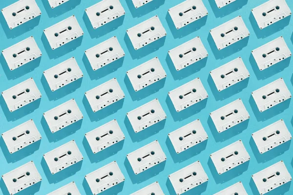 Beyaz kasetlerle yapılmış yaratıcı bir model. Asgari retro flate Cyan arkaplan yatıyordu.