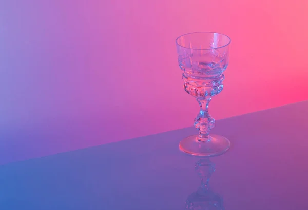 Neon parlak pembe ve mavi renklere karşı cam. Asgari parti hayatı konsepti.
