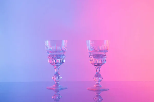 Two glasses for drink a color neon background. Minimal concept.