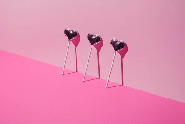 Sevgililer Günü. Pembe arka planda lolipop kalp şekeri. Asgari konsept.
