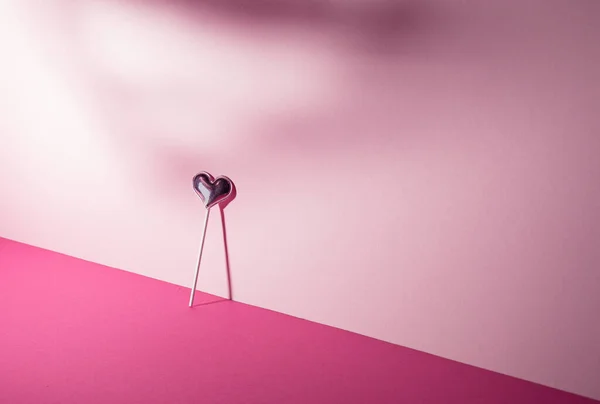 Sevgililer Günü. Pembe arka planda lolipop şeker kalbi. Asgari konsept.