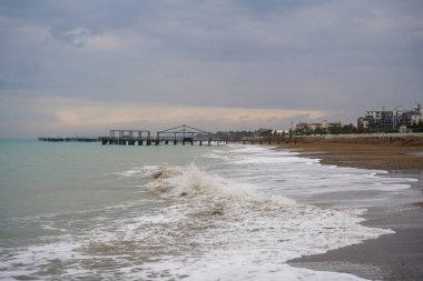 Kışın boş sahilde dalgalar ve rıhtımlar