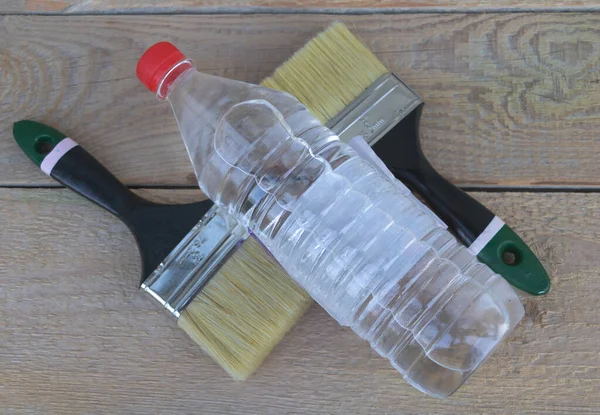 Una botella de acetona - dos pinceles y guantes en el fondo - fondo de madera - Concepto de construcción — Foto de Stock