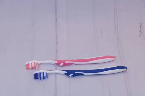 Twee Tandenborstels Een Blauwe Een Roze Met Grijs Oppervlak Met — Stockfoto