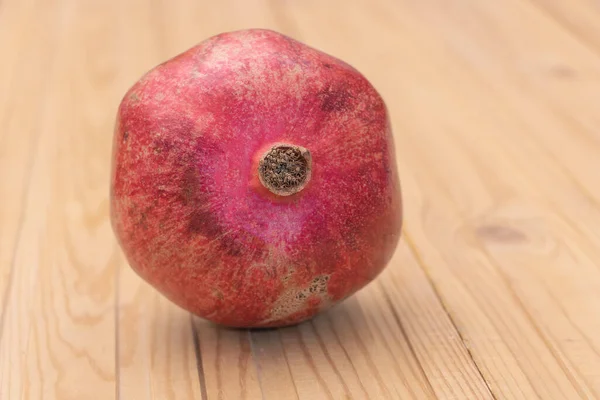 Close-up tiro de uma fruta romã no fundo de madeira - Conceito de benefícios romã — Fotografia de Stock