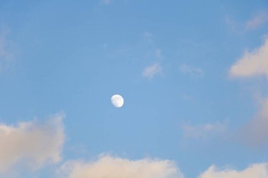 Güzel beyaz bulutlar ve gökyüzünde küçük bir ay..
