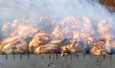 Izgarada dumanla pişirme işlemi sırasında şişlerin yakın çekimini yap.