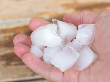 Ice cubes in the hand of a man close up.