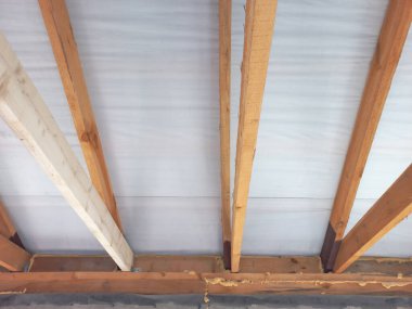 A new roof of a house shot from inside close up - wooden beams installed one meter apart.
