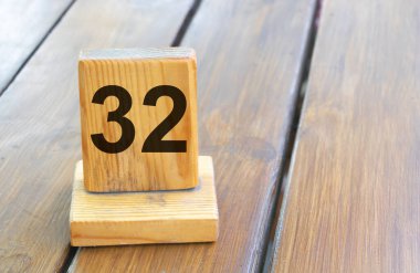 Wooden priority number 32 on a plank tab.