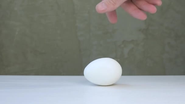 Das Weiße Hühnerei Auf Einen Weißen Tisch Legen Und Rotieren — Stockvideo