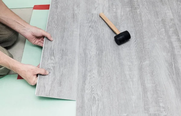 Adam yere bir kuvars kaplaması serer. Binanın tamiri. Çağdaş döşeme.