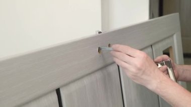 Tahta kapıya metal bir kapı kolu yerleştirilmiş. Onarım işi.