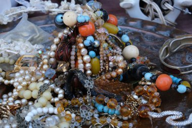 Çok renkli doğal taştan boncuklar sergileniyor. Bit pazarındaki antika mücevherler. Taşlardan, boncuklardan ve metalden yapılmış kolyeler. Gümüş broşlar. El işleri, nakış işleri, mücevher yapımı..