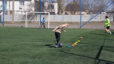 25 Mart 2022 Ukrayna, Dnipro, Nike logoları. Futbolcular sokakta antrenman yapıyor. Sahada spor malzemeleri var. Gol! Gol! Çocuklar savaş sırasında futbol sahasında oynuyorlar..