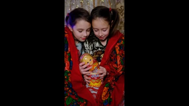 两个漂亮的女孩穿着传统图案的漂亮的彩绘围巾坐在一起 孩子们在玩毛毯 斯拉夫服装和木制玩具 — 图库视频影像