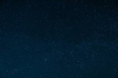 Güzel gece manzarası. Aysız ve bulutsuz açık bir gökyüzünde yıldızlar. Evin çatısında bir gece sahnesi.