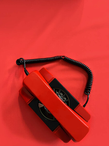 Red telephone on a red background with copy space. Direct telephone line of communication between the leaders of the superpowers.Concept: negotiations, peace agreement, confrontation, wartime, war