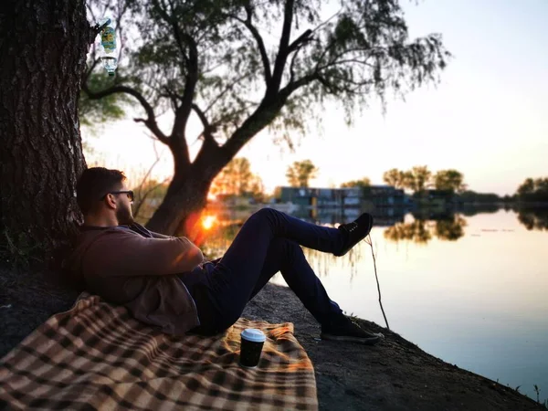 Man Picnic Plaid Blanket Drinks Coffee Looks Sunset Man Rests — Foto de Stock