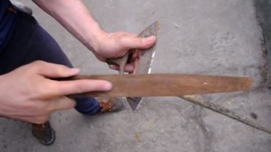 Çapayı keskinleştirme süreci. Bahçe aletleri erkekler tarafından toprakta çalışmak için hazırlanır. Sebze yetiştirmek için eski açık hava ekipmanları. Konsept: tarım hazırlığı.