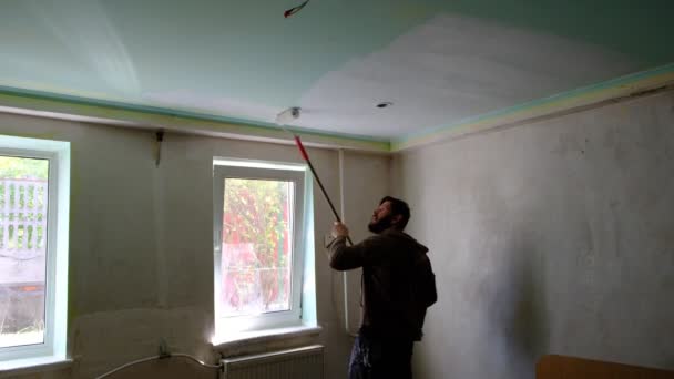 Man Makes Repairs House Painting Ceiling Long Stick Roller Ceiling — Stockvideo