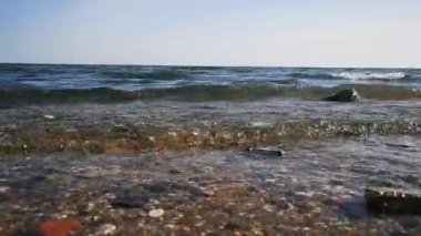 Kumsalda dalgaları yenmek. Zümrüt renginde güzel bir su manzarası, hareketli rüzgarlı deniz. Kıyıdan okyanusa manzara, tüm aile için dinlenme ve dinlenme yeri.