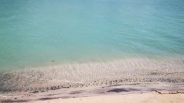 Kumsalda dalgaları yenmek. Zümrüt renginde güzel bir su manzarası, hareketli rüzgarlı deniz. Kıyıdan okyanusa manzara, tüm aile için dinlenme ve dinlenme yeri.