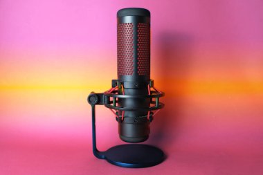 Podcast ve ses kaydı için mikrofon. Reklam ve ses kaydı için stüdyo mikrofonu. Kırmızı aksanlı siyah renk, metin için boşluk olan kenar görünüm.