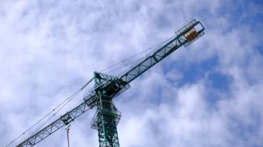Yüksek bir binanın inşaatı sırasında vinç inşaatı. Ağır bir yük taşıyor. Kule vinçleri bir ev inşa ediyor. Beton bina yapım aşamasında. İnşaat alanı