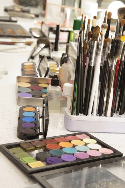 Sets of makeup brushes and cosmetics on a bright workplace of a make-up artist.Brushes for applying eye shadow and foundation. Concept: makeup cabinet, stylist and makeup artist tools