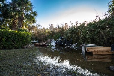 Napoli, Florida, ABD - 28 Eylül 2022: NEWS - Ian Kasırgası 'nın suları ve çamurları arasında Vanderbilt Sahili, Napoli, Florida yakınlarında bir tekne ve bir ATV bulunmaktadır. Sadece editör