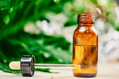 Esrar yapraklarının bulanık arka planında bir şişe cbd yağı, PETS CBD Petrol Düşürme Alternatif Terapi Olarak