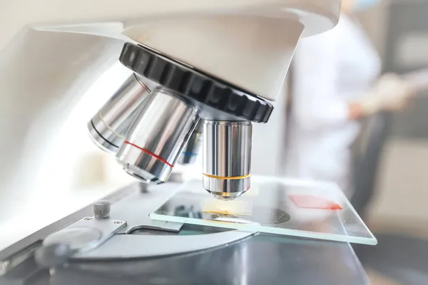Biochemie laboratorní výzkum, Chemik analyzuje vzorek v laboratoři s mikroskopem zařízení — Stock fotografie