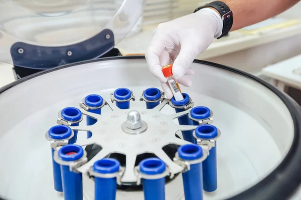 Técnico carregando uma amostra para máquina de centrifugação no laboratório médico ou científico — Fotografia de Stock