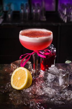 Siyah arka planda limonlu pembe kokteyl içeceği.