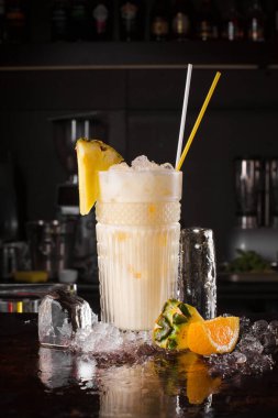 Siyah arka planda ananas ve buz küplü ağrı kesici kokteyli.