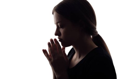 Beyaz arka planda dua etmek için kollarını kavuşturmuş kadın silueti.