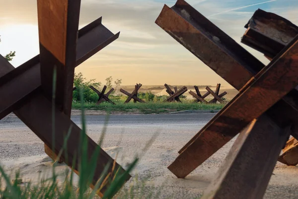 Steel anti-tank obstacles on the road.